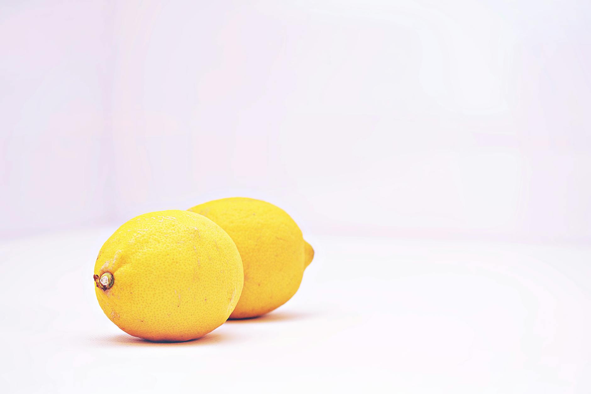 Two vibrant fresh lemons on a white background