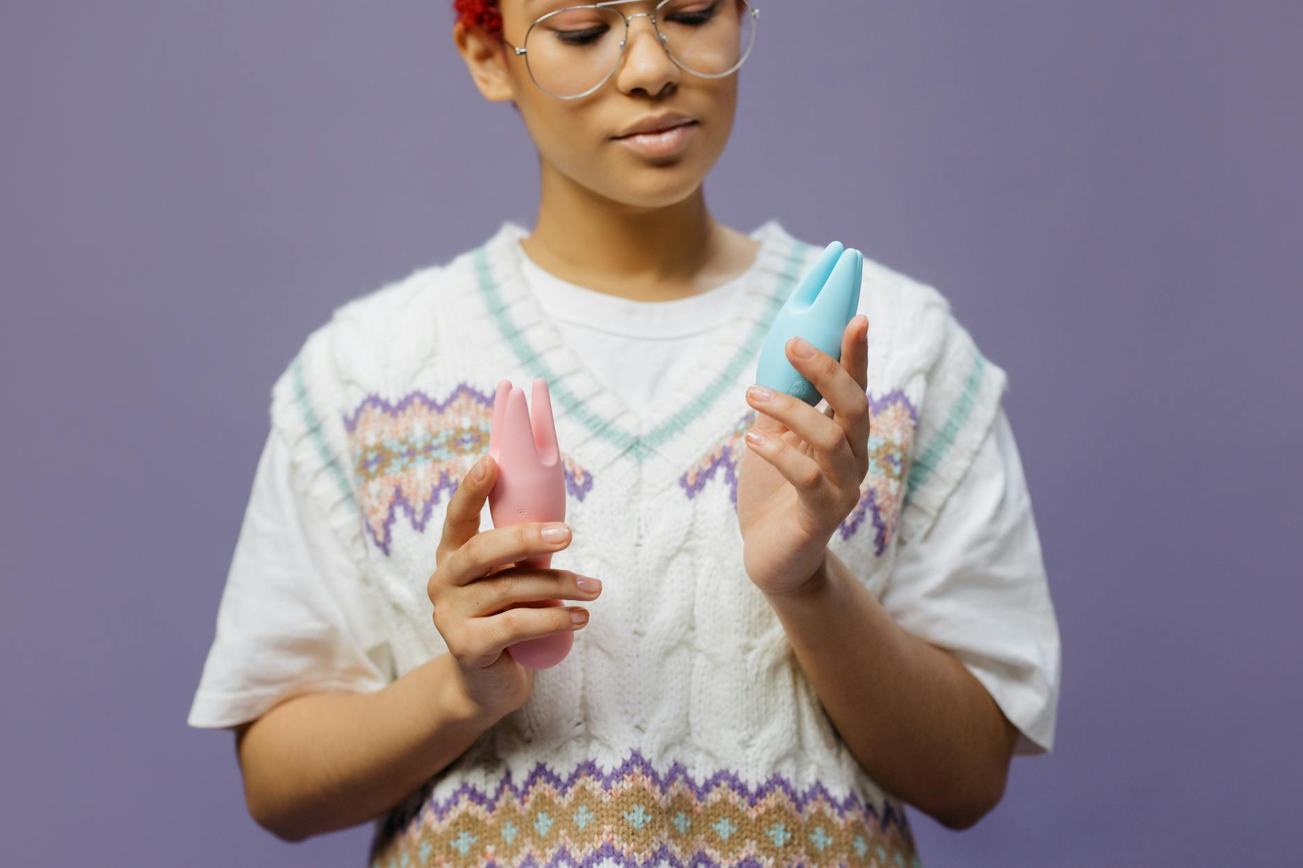 Person holding colorful vibrators thoughtfully